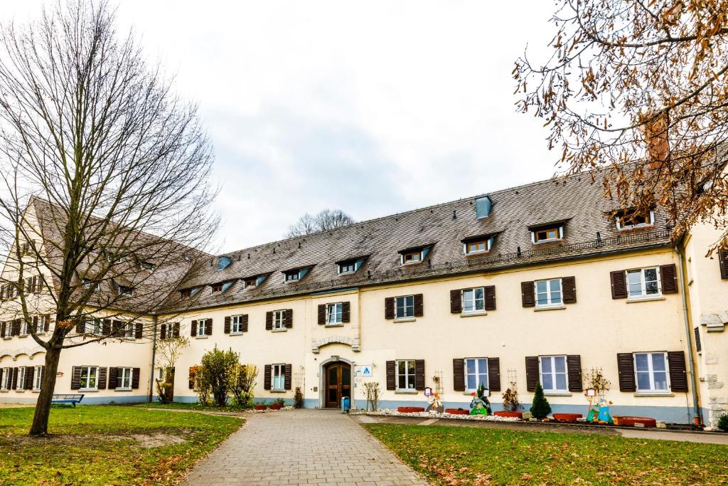 een groot wit gebouw met een grijs dak bij Jugendherberge Regensburg in Regensburg