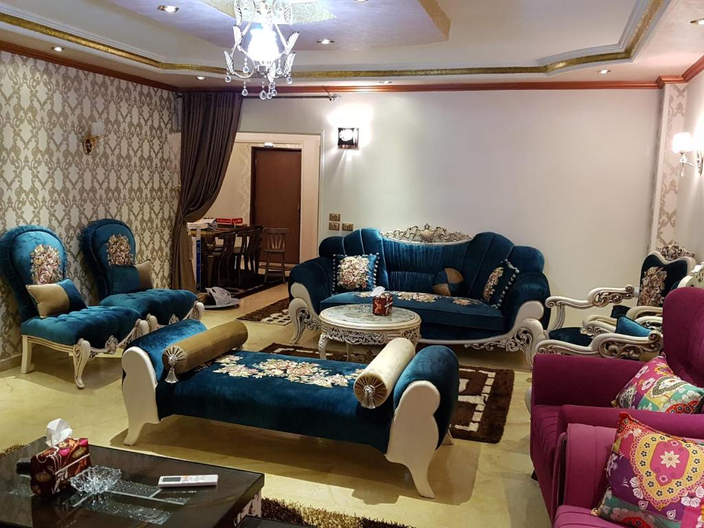 Al Mansoura Apartment في المنصورة: غرفة معيشة مع أرائك زرقاء وطاولة