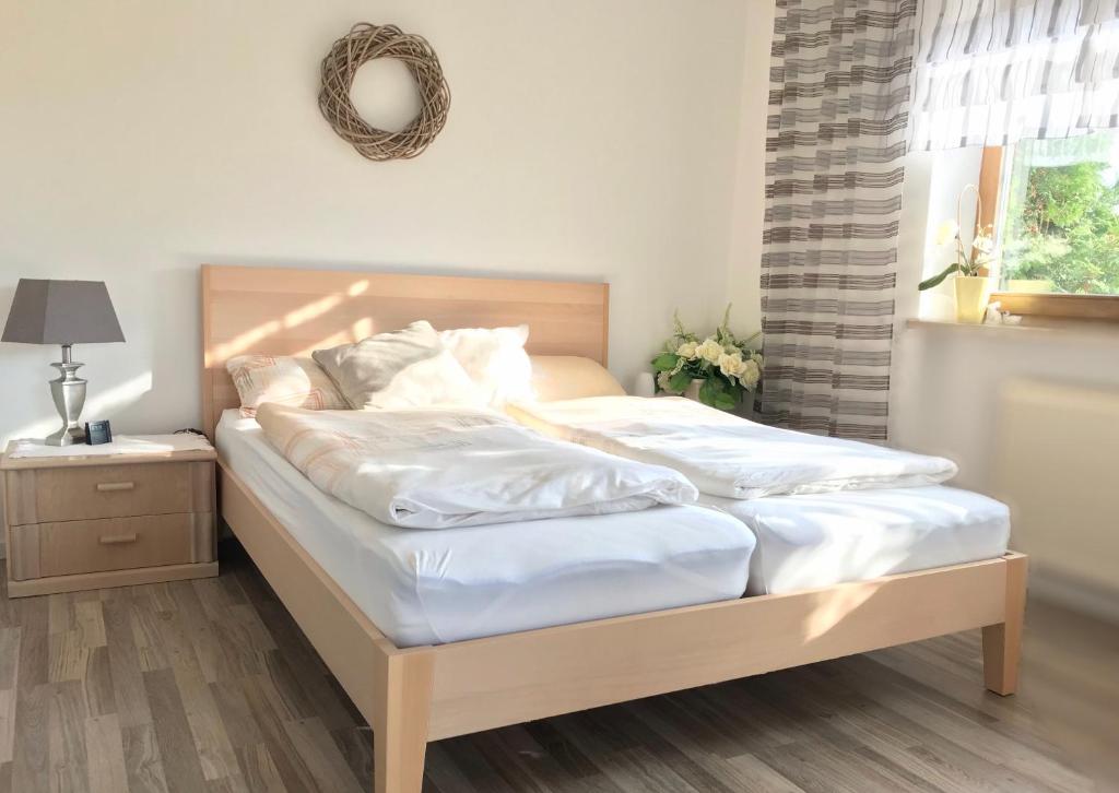 um quarto com uma cama com lençóis brancos e uma janela em Apartment am Stadtpark em Neumarkt in der Oberpfalz