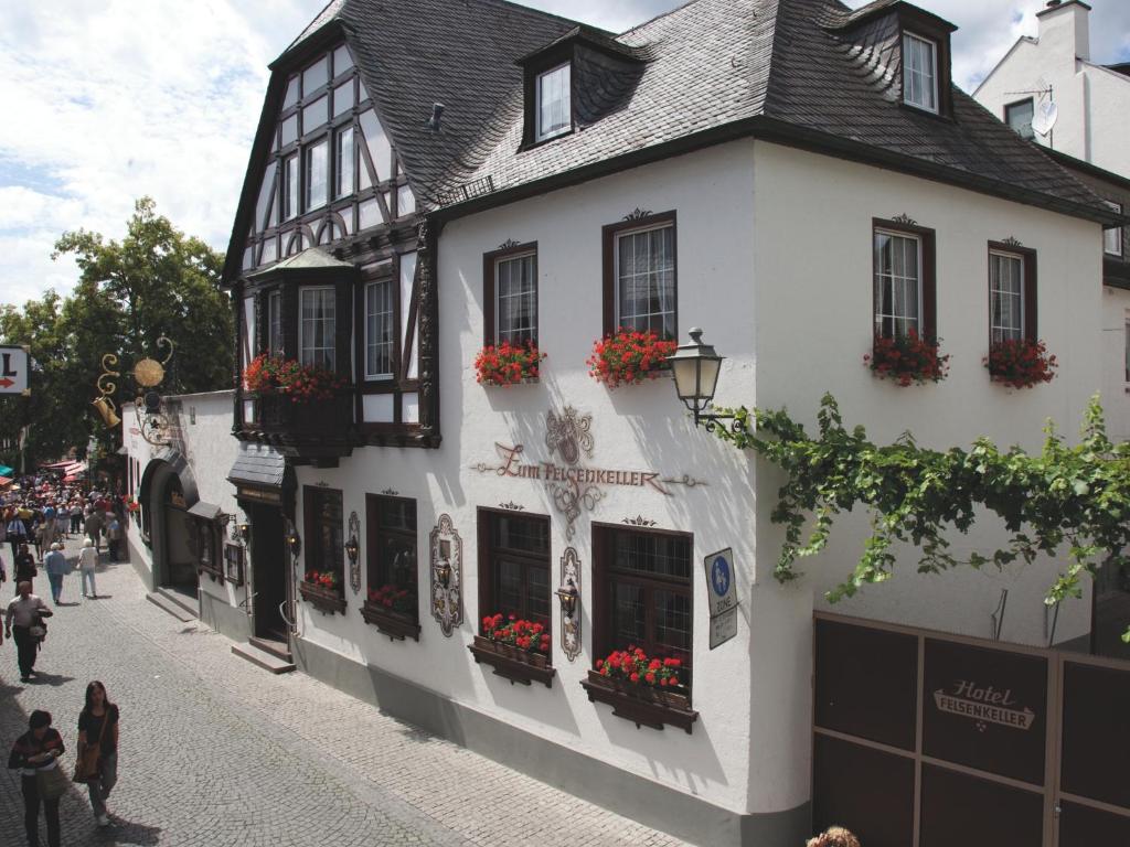 ein weißes Gebäude mit Blumenkästen an der Straßenseite in der Unterkunft Hotel Felsenkeller in Rüdesheim am Rhein