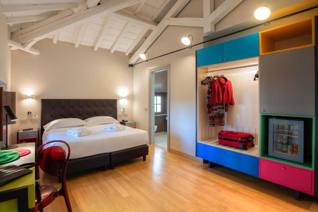 Un dormitorio con una cama y un escritorio con una maleta roja. en Albergo Etico Roma, en Roma