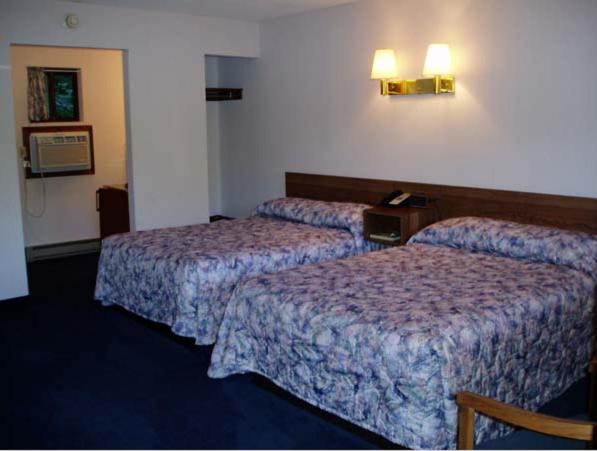 Postel nebo postele na pokoji v ubytování Tall Pines Motel
