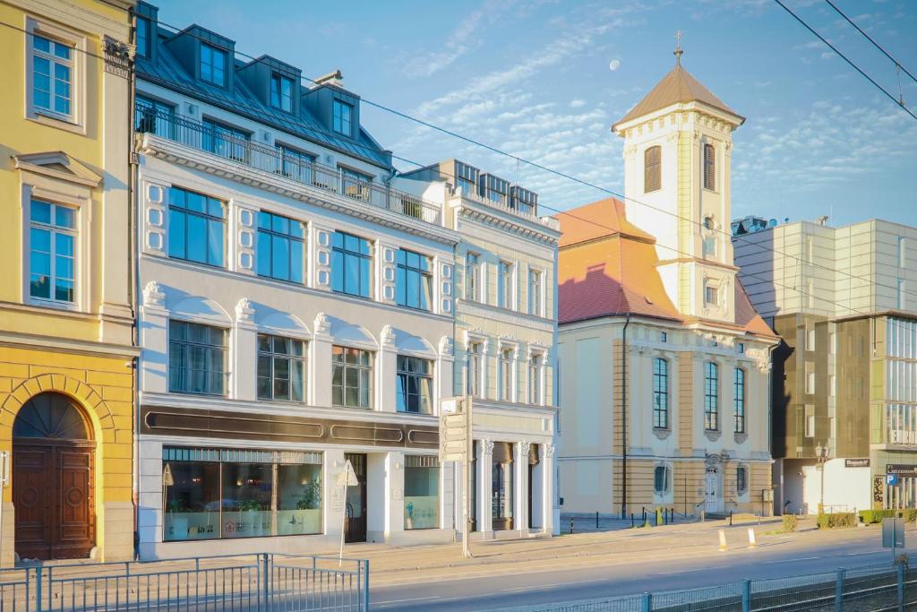 grupa budynków na ulicy z wieżą zegarową w obiekcie Kamienica Pod Aniołami we Wrocławiu