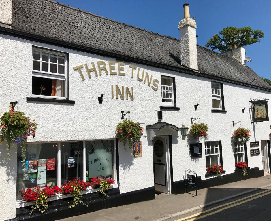 Una posada de tres empresas con flores en la ventana en The Three Tuns, en Chepstow