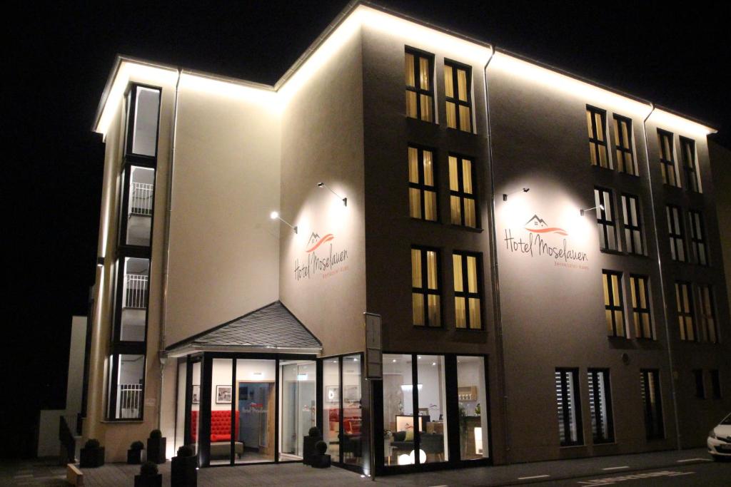 een groot gebouw met 's nachts verlichting bij Hotel Moselauen in Bernkastel-Kues