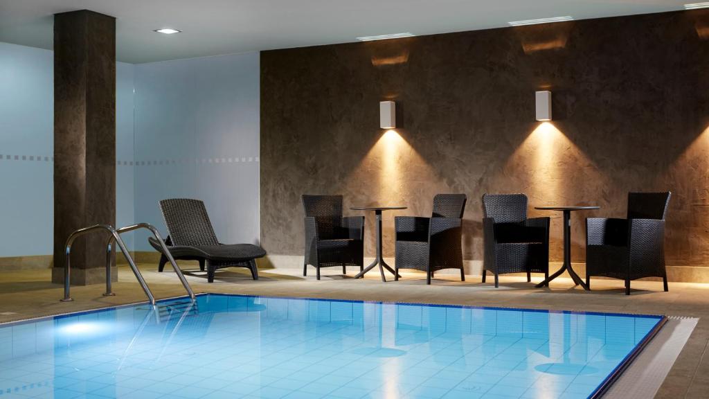 eine Hotellobby mit einem Pool, Stühlen und einem Tisch in der Unterkunft OREA Resort Santon Brno in Brünn