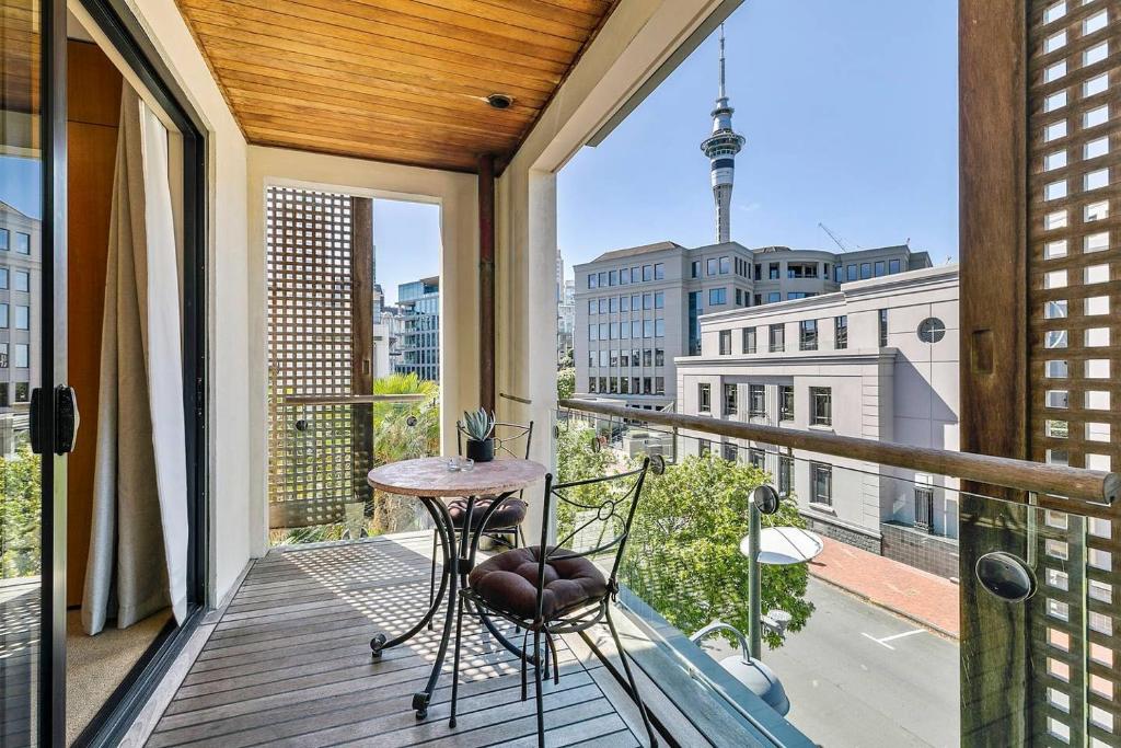 a balcony with a table and chairs and a view at Enormous One Bedroom Beauty in CBD! Free Parking in Auckland
