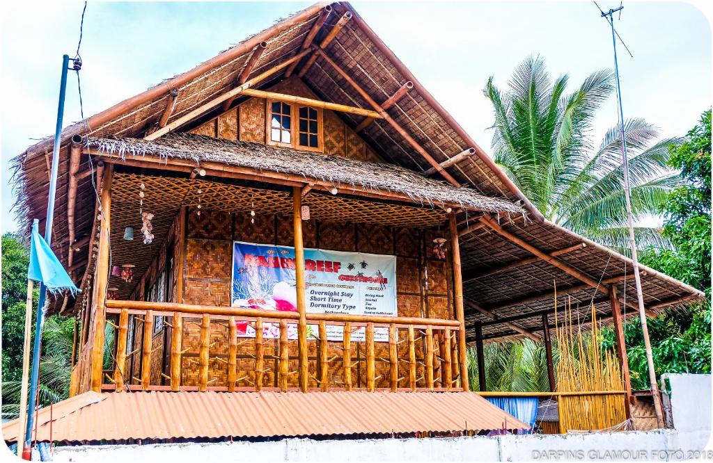 ein Bambushaus mit einem Schild davor in der Unterkunft Darpins Guesthouse in Dauin