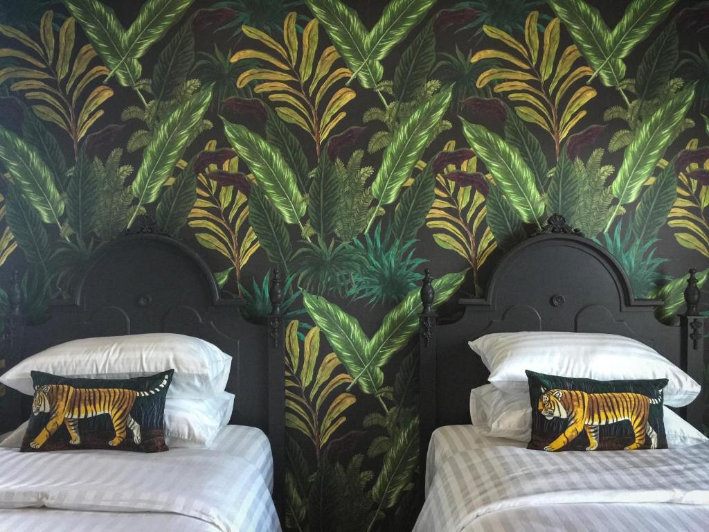 曼谷的住宿－WIW mini hotel，一间卧室配有两张床和壁画