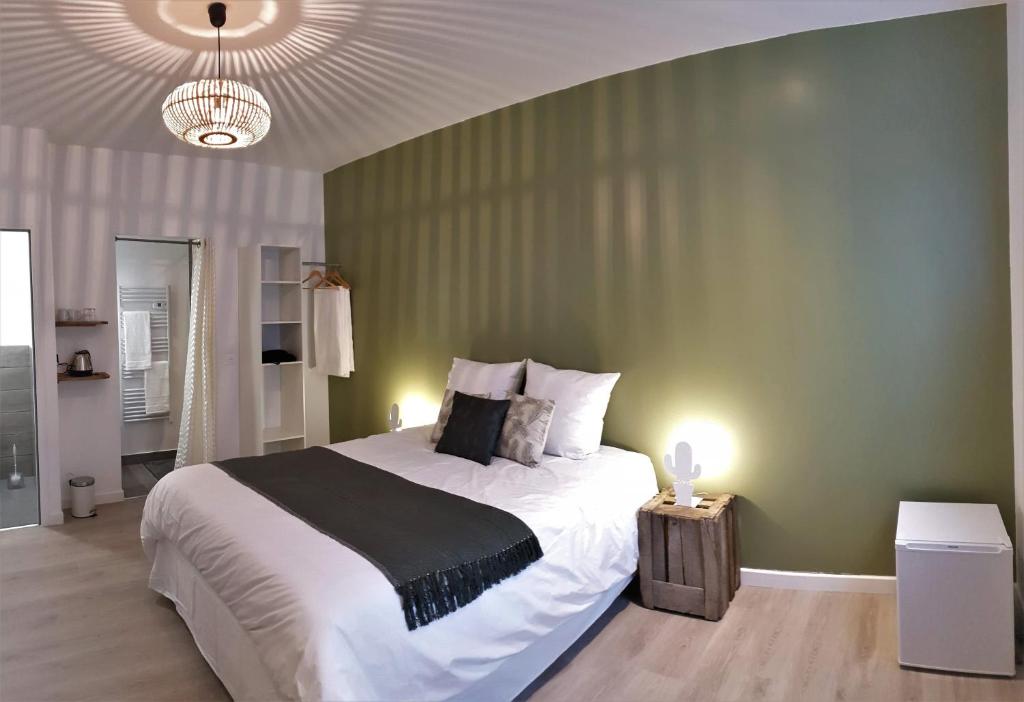 Chambres privées hyper-centre Epernay lit 160x200cm في إيبيرني: غرفة نوم بسرير كبير وجدار أخضر