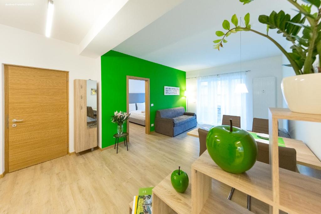 a living room with a green accent wall at City Charme Apartments in Bolzano