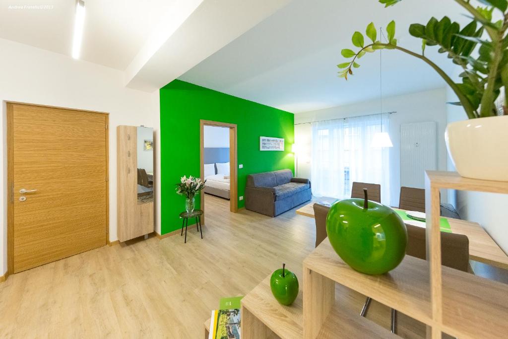 sala de estar con pared de acento verde en City Charme Apartments, en Bolzano