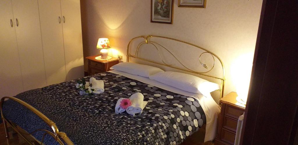 シルミオーネにあるApartament Casa Vacanze Niko ap cir CNI00247のベッドルーム1室(タオル、花付)