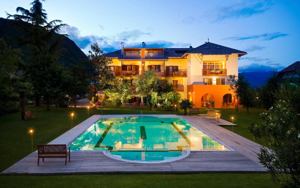 une villa avec une piscine en face d'une maison dans l'établissement Hotel Weingut Klosterhof, à Caldaro
