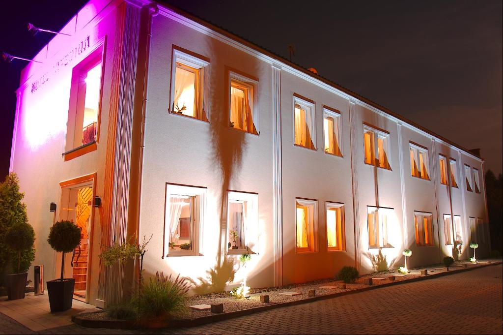 a white building with lights on the side of it at Hotel Imperium in Piekary Śląskie