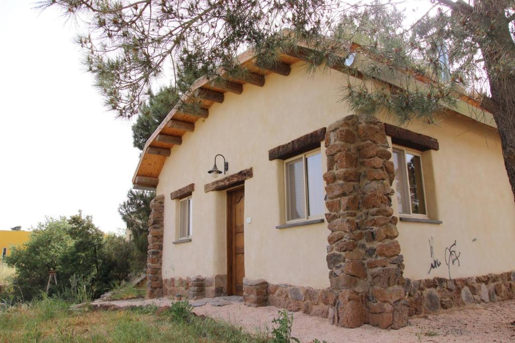 a small stone house with an arched doorway at Earth Zimmer El Rom in El-Rom