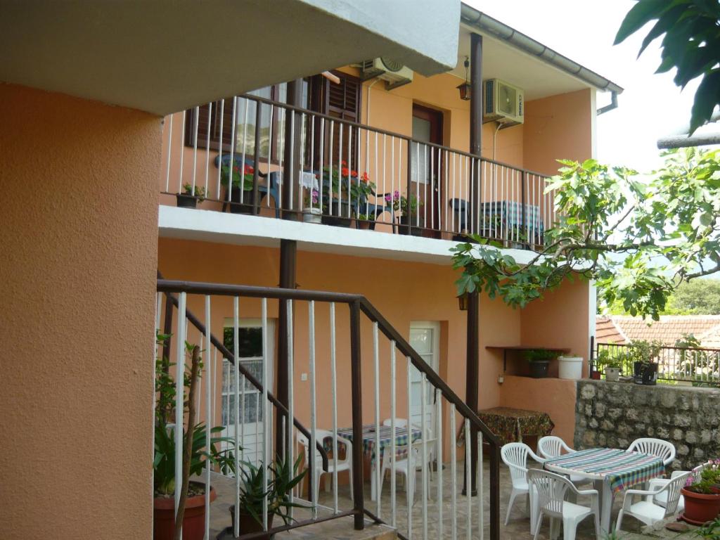 a balcony of a building with a table and chairs at Rooms Banićević in Risan