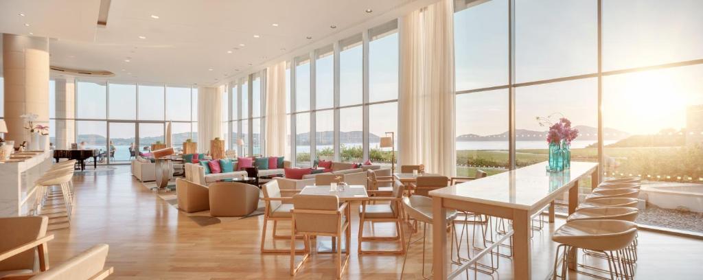 a restaurant with tables and chairs and windows at Sun Gardens Dubrovnik in Dubrovnik