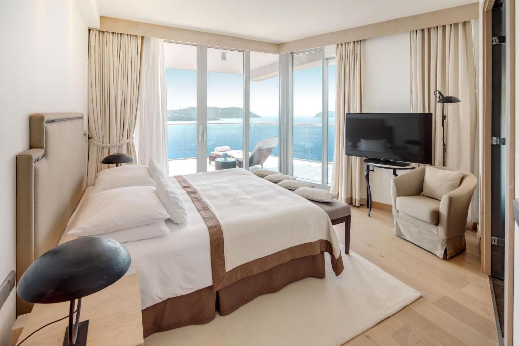 a bedroom with a large bed and a large window at Sun Gardens Dubrovnik in Dubrovnik