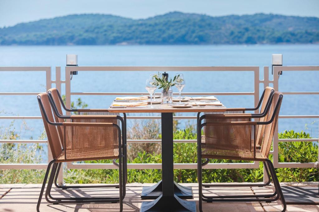 a table and chairs with a view of the water at Sun Gardens Dubrovnik in Dubrovnik