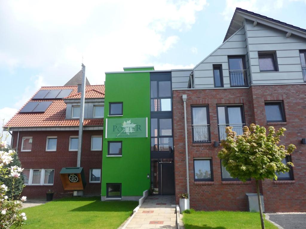 an apartment building with a green facade at Hotel & Restaurant Pötter in Emsdetten