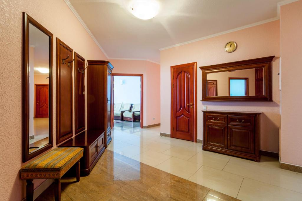 a living room with a mirror and wooden cabinets at Large luxury 4-room apartment with a sauna, near the metro Levoberezhnaya in Kyiv