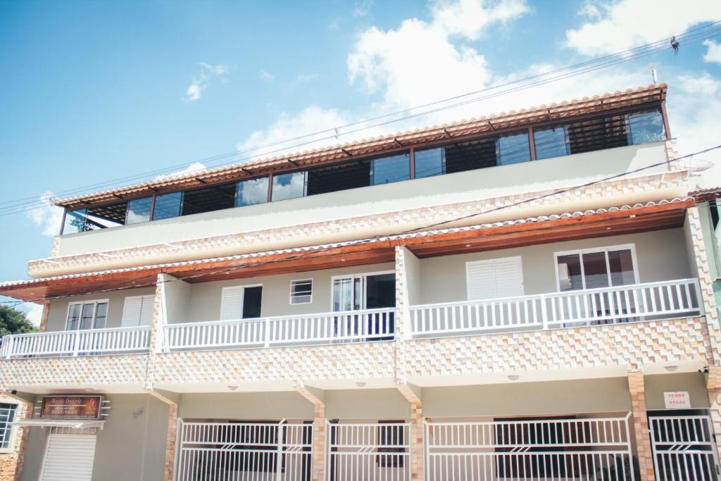 a white building with a balcony at Souza Reis Flat in São Thomé das Letras