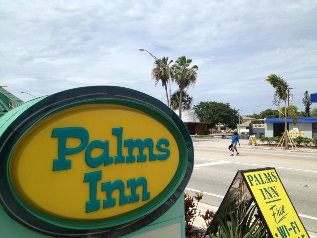 a sign for a pills inn on the side of a street at Palms Inn in Dania Beach