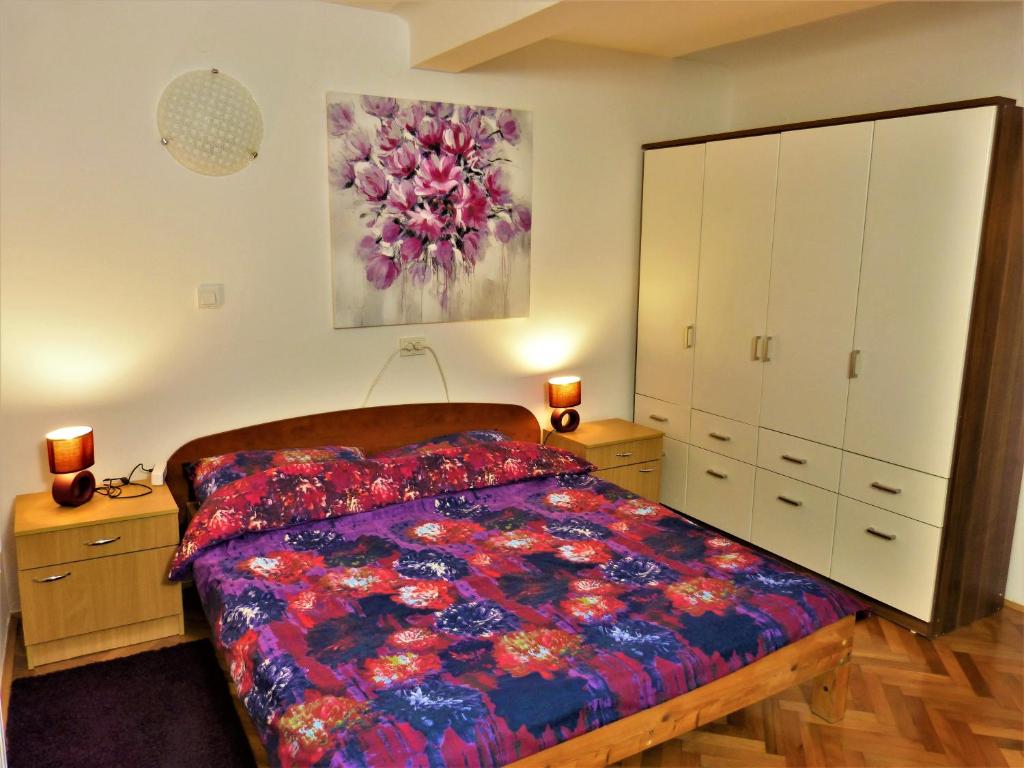 a bedroom with a bed and a painting on the wall at Apartman La Linea - Free parking in Zagreb