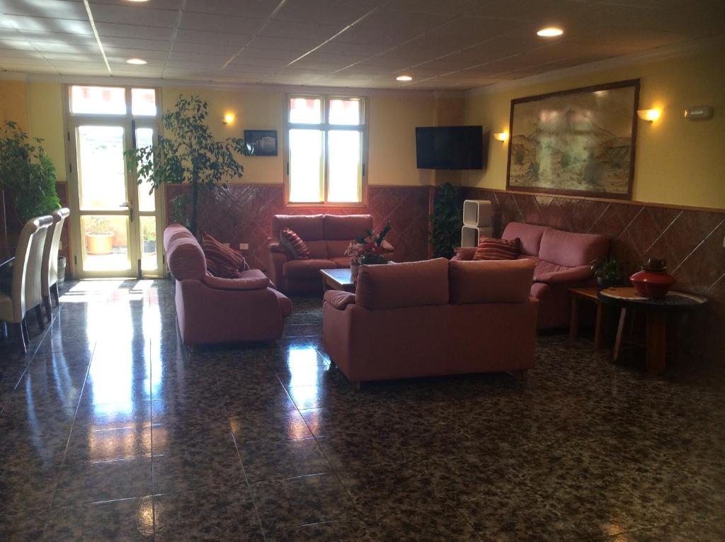 a living room with couches and tables and windows at Hotel Sonia Chipude in El Cercado