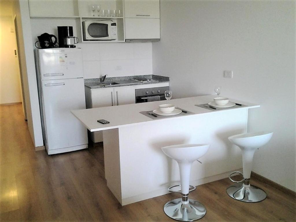 a kitchen with a counter with two bar stools at Excelente Departamento, piso alto in Buenos Aires