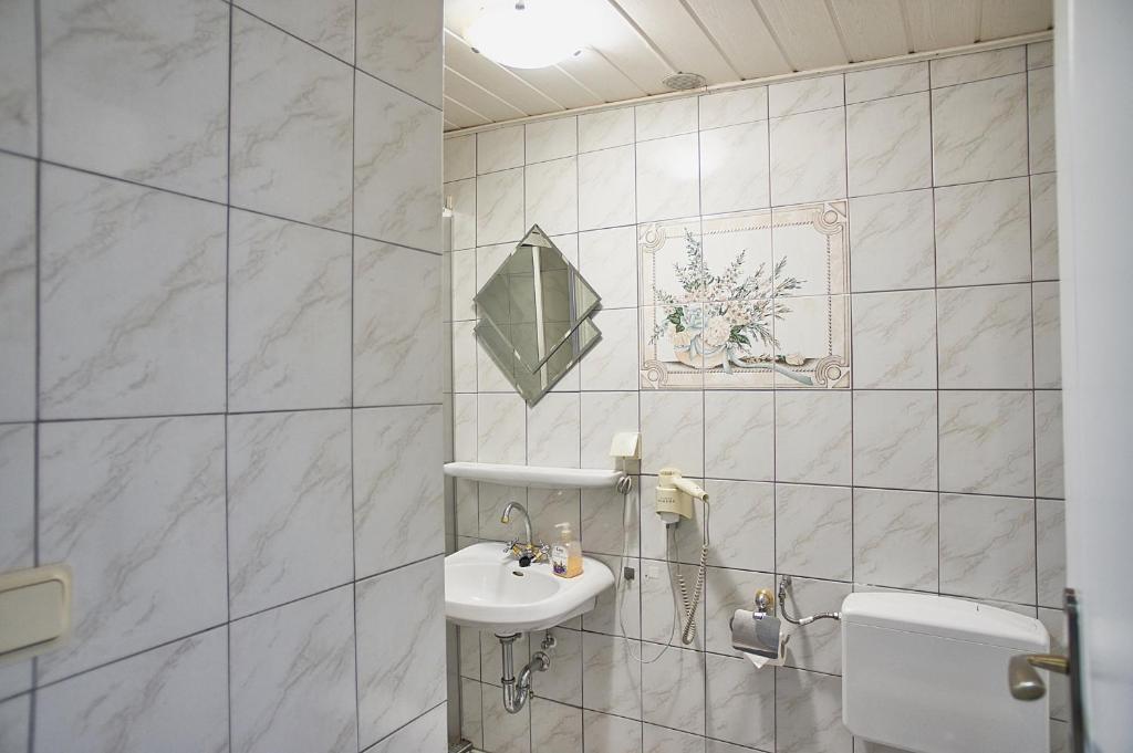 クアオルト・オイビンにあるフェリエンハウス ペギーの白いバスルーム(洗面台、トイレ付)