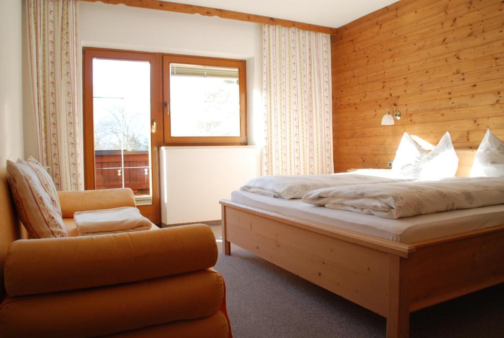 ミエミングにあるFerienwohnung Frauenhofferのベッドルーム1室(ベッド1台、椅子、窓付)