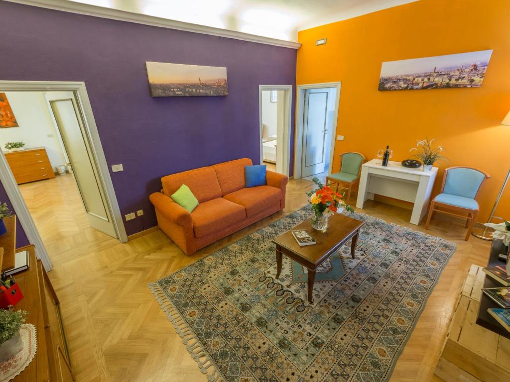 Hotel Paolo and Carlotta's Home, a living room with an orange couch and a table at Paolo and Carlotta's Home in Florence