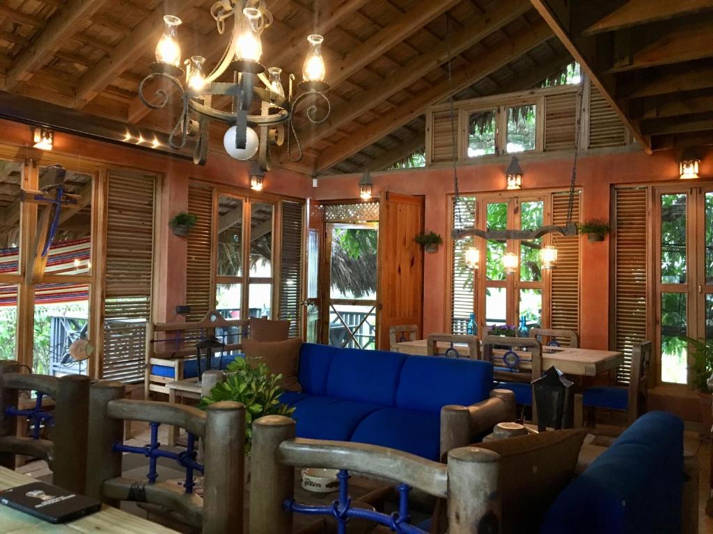 a living room with a blue couch and tables and windows at Villa La Loma in Concepción de La Vega