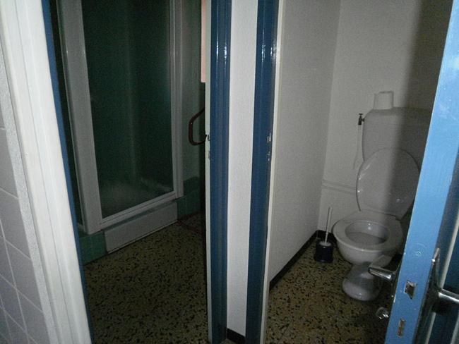 a bathroom with a toilet and a glass shower at 5COMA2 Appartement proche plage in Collioure