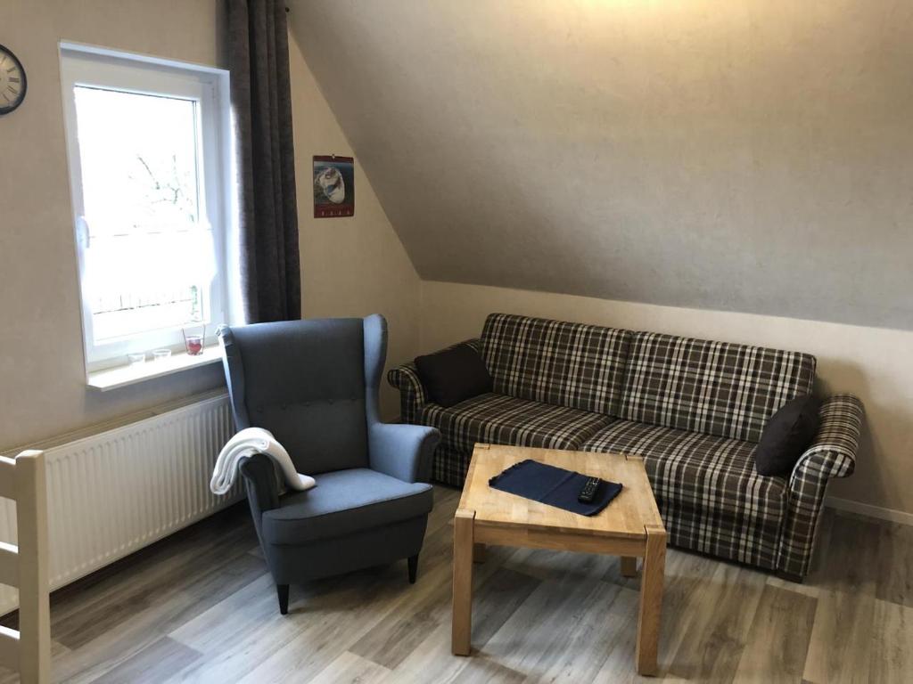 sala de estar con sofá, silla y mesa en Fewo Imke en Norden