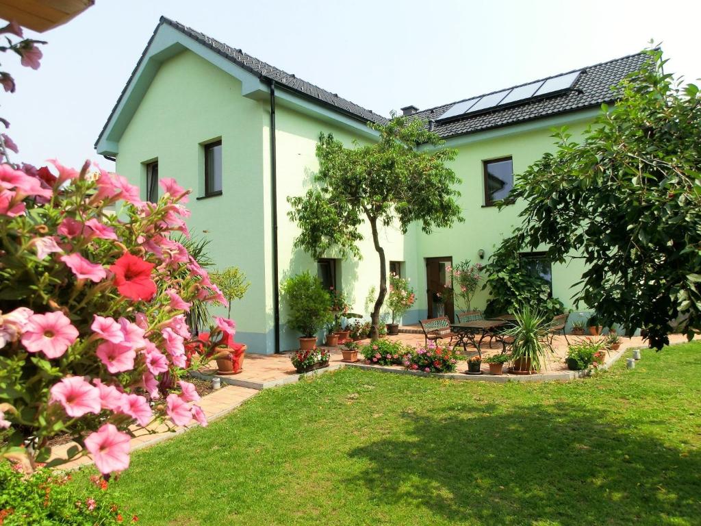 a house with pink flowers in the yard at Vila Evička in Sobotka