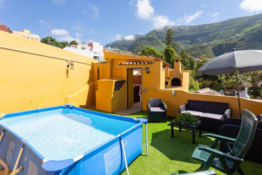 un cortile con piscina e una casa di Canarian House with views and pool a Los Realejos