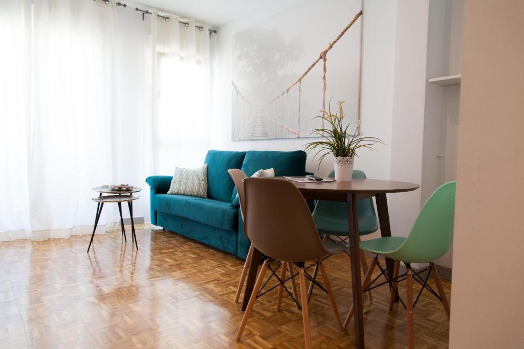 - un salon avec un canapé bleu et une table dans l'établissement Apartamento City SOLO ADULTOS, à Madrid