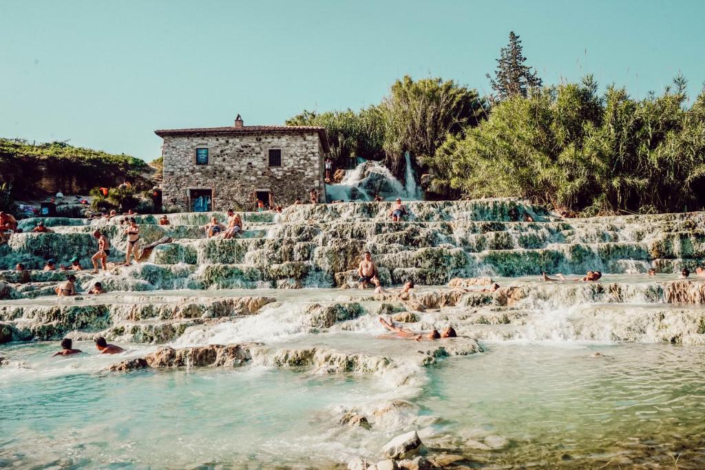 people swimming in a waterfall at a water park at Agriturismo Bio Aia della Colonna in Saturnia