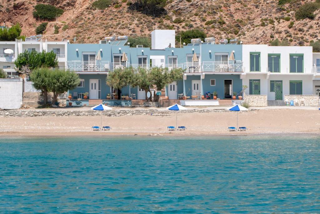 een uitzicht op een strand met blauwe huizen bij Kozas Superior Apartments in Archangelos