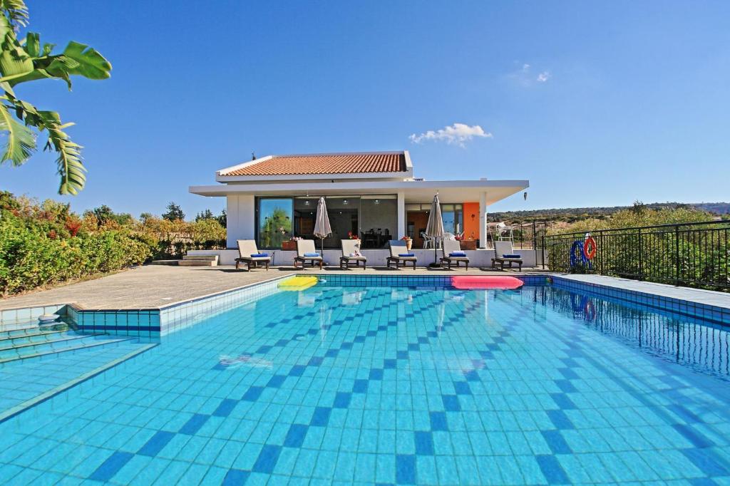 a swimming pool in front of a villa at Villa Sophia Latchi in Polis Chrysochous