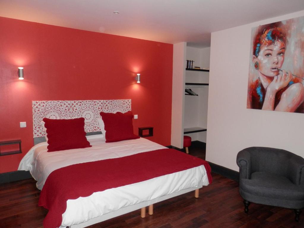 ein rotes Schlafzimmer mit einem Bett und einem Gemälde an der Wand in der Unterkunft Appart-hôtel Chanzy / Angoulême in Angoulême