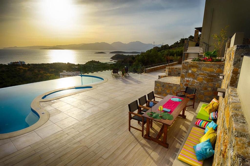 d'une terrasse avec une table et des chaises à côté de la piscine. dans l'établissement Villa Sophia, à Agios Nikolaos
