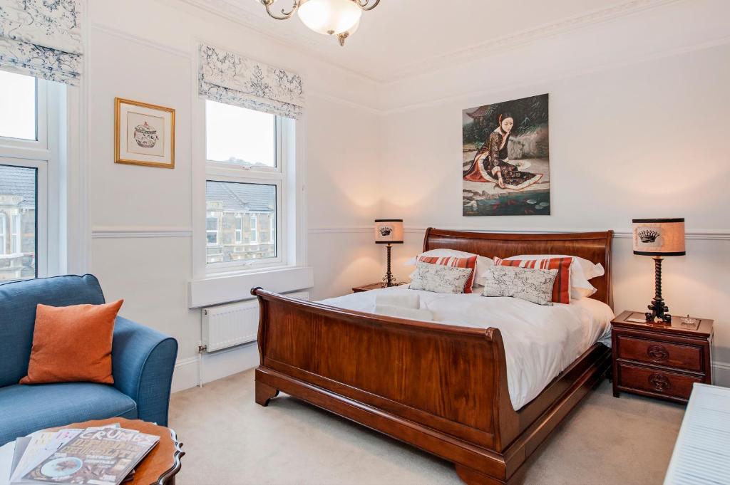 1 dormitorio con 1 cama y 1 sofá azul en Apple Tree boutique B&B, en Bath