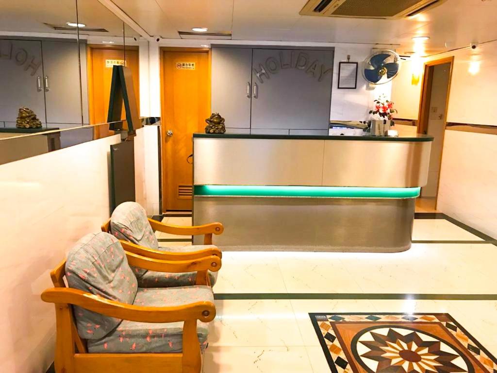 - une salle d'attente avec 2 chaises et un comptoir dans l'établissement Holiday Guest House, à Hong Kong