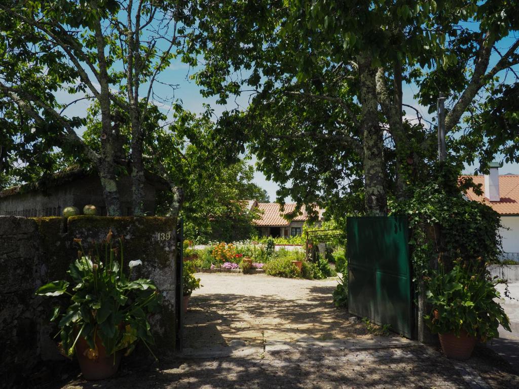 una puerta a un jardín con árboles y plantas en Casa de Pereiró en Soajo