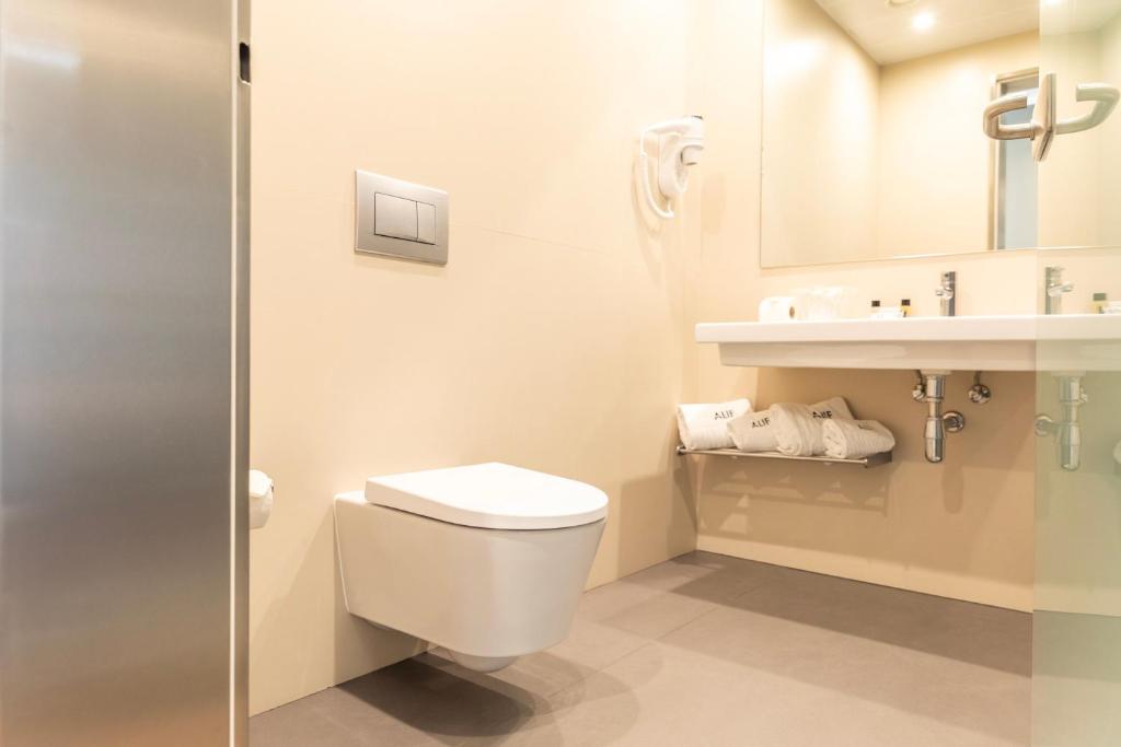 A bright, accessible-looking bathroom with a wall-hung toilet and open vanity.