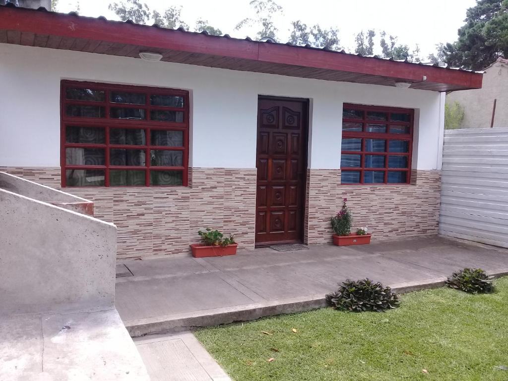 una casa con 2 puertas de madera y una acera en Tu descanso ideal en Mar del Plata